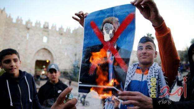 شباب فلسطيني يحرقون صورة ترامب بعد قراره