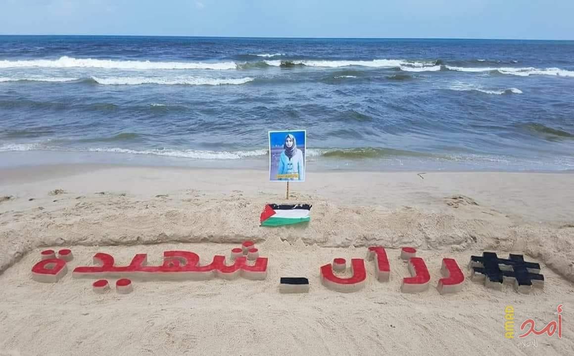 الفنان "محمد طوطح" ينحت اسم الشهيدة "رزان" على شاطئ غزة (صور)