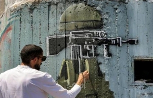 فرانس برس: فنان فلسطيني يندد بالاحتلال من خلال رسوم غرافيتي على "الجدار"
